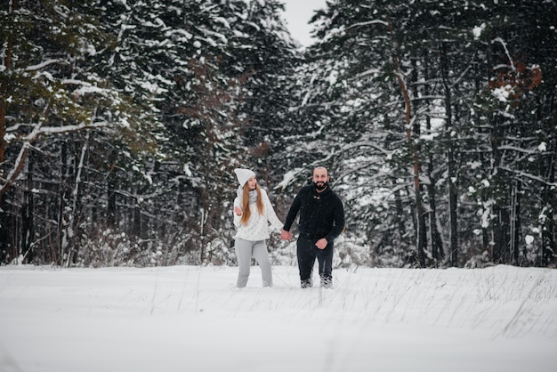 Pareja jugando con nieve en el bosque