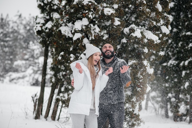 Pareja jugando con nieve en el bosque