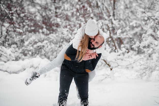 Pareja jugando con nieve en el bosque