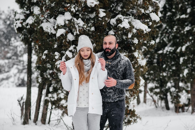 Pareja jugando con nieve en el bosque