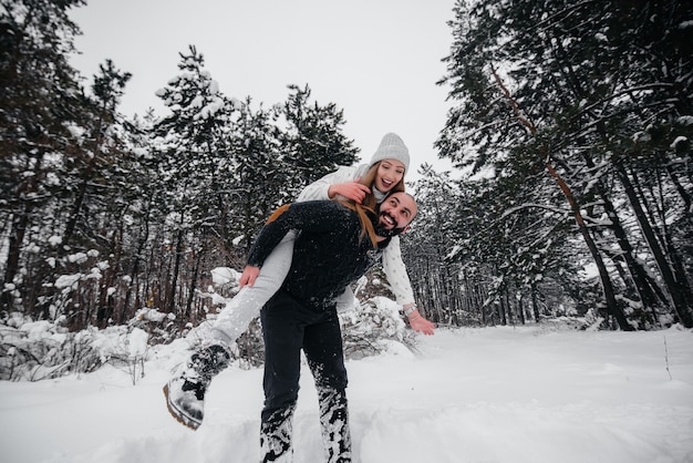 Pareja jugando con nieve en el bosque.