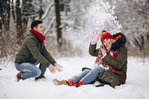 Pareja jugando en la nieve en invierno