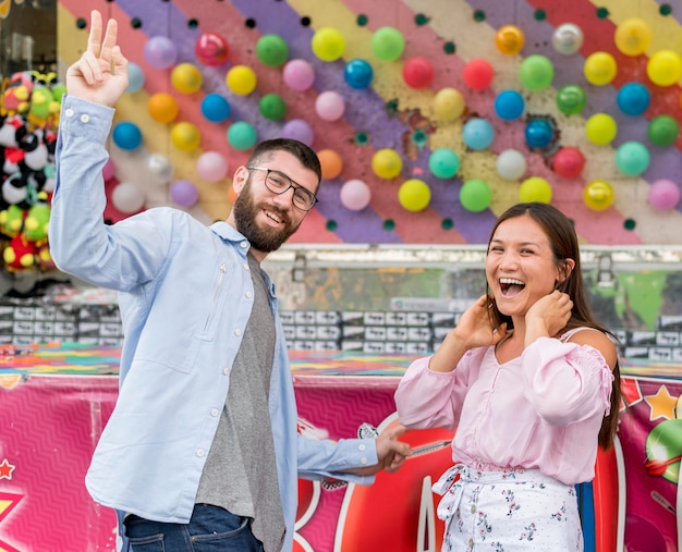 Foto pareja jugando en el parque de atracciones