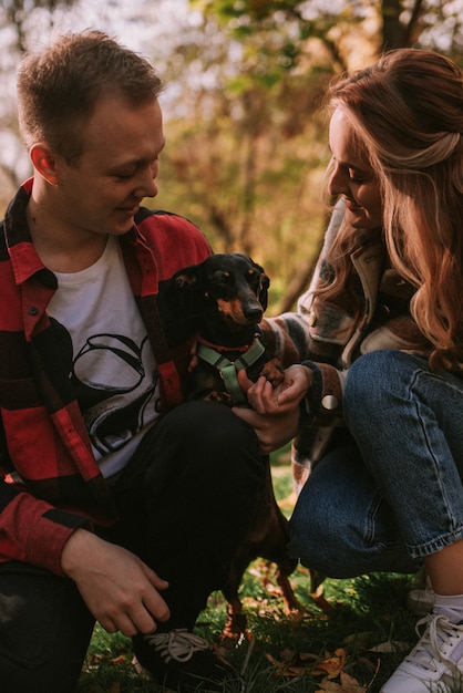 Foto pareja jugando con perro en el parque