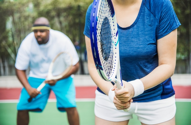 Pareja jugando tenis en equipo