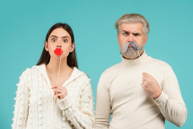 Pareja con labios y bigote falso. Divirtiéndose. Concepto de cabina de fotos. Pareja divirtiéndose con labios y bigote falso.