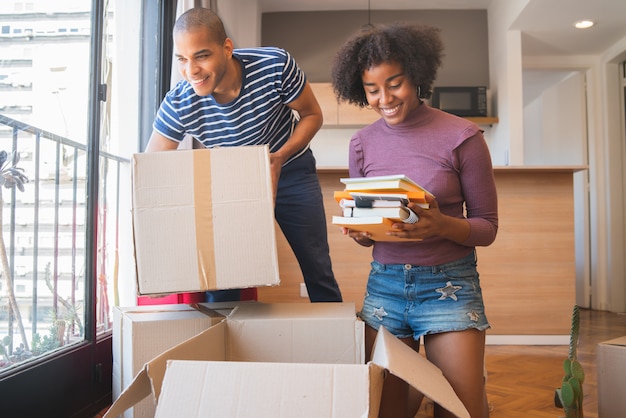 Pareja latina desempacando en su nueva casa.