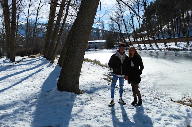 Pareja de latinos y caucásicos en una escena nevada en invierno