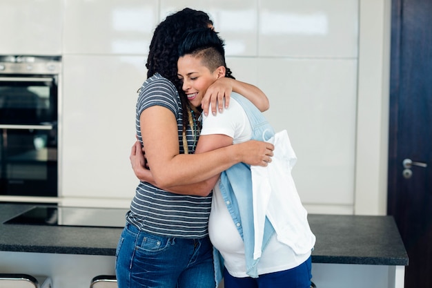 Pareja de lesbianas abrazándose en casa