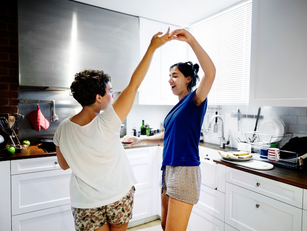 Pareja de lesbianas bailando en la cocina