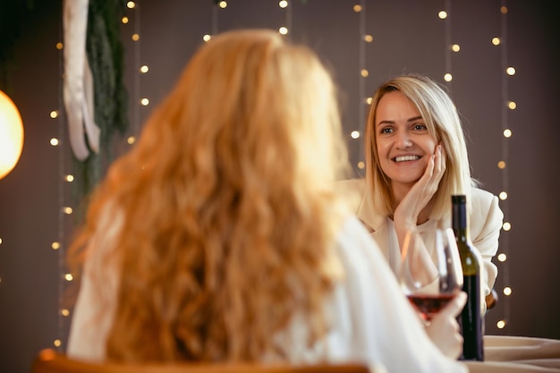 Pareja de lesbianas cenando en un restaurante. Chica dando un regalo a su novia