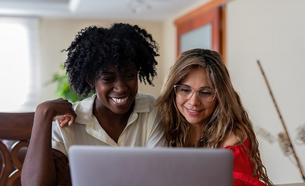 Pareja de lesbianas diversa haciendo videollamadas en la computadora portátil