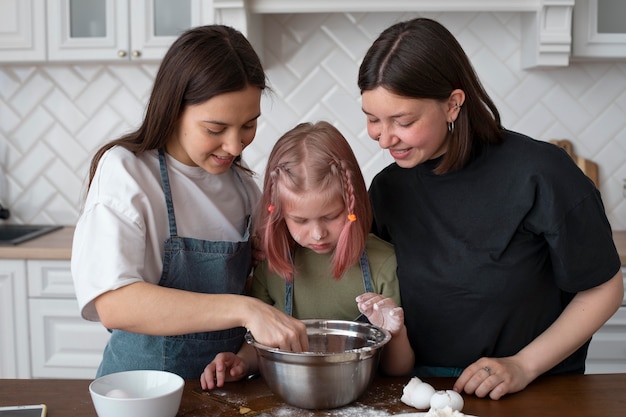 Foto pareja lgbt pasar tiempo junto a su hija en la cocina