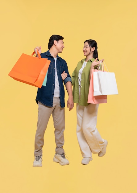 Una pareja lleva con alegría bolsas de compras que simbolizan la relación de consumismo y la terapia de venta al por menor