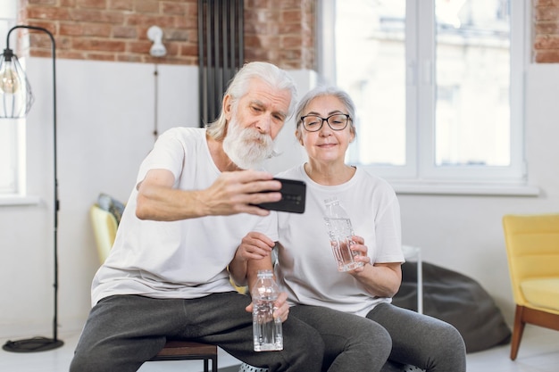 pareja madura, en, activewear, toma, selfie, en, smartphone