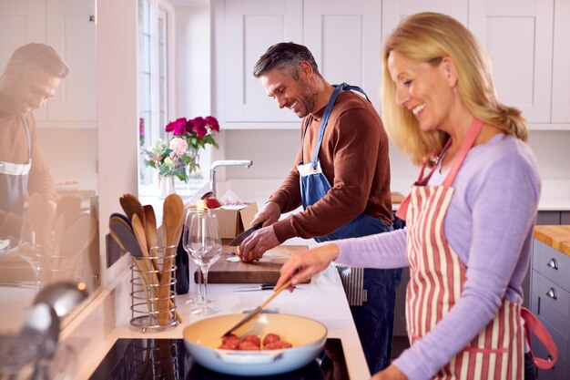 pareja madura, en casa, en, cocina, picar, ingredientes, y, cocina, en, sartén, preparar, comida, juntos