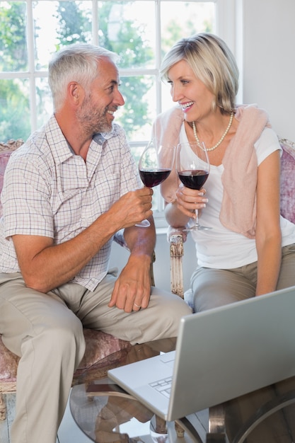 Pareja madura con copas de vino en casa