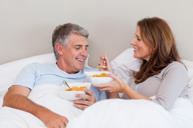 Pareja madura desayunando en la cama