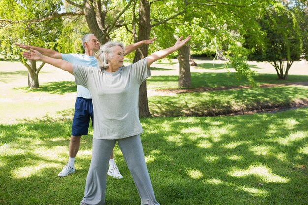 Pareja madura estirando las manos en el parque