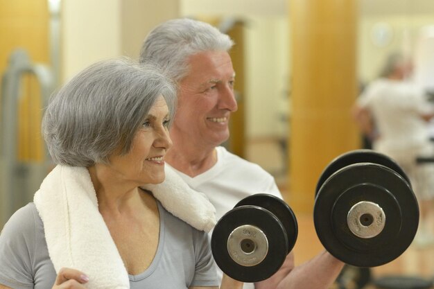 Pareja madura en el gimnasio trabajando juntos