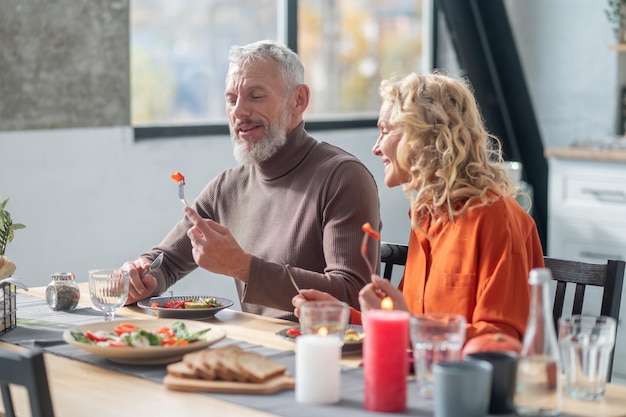 Pareja madura sentada a la mesa y cenando