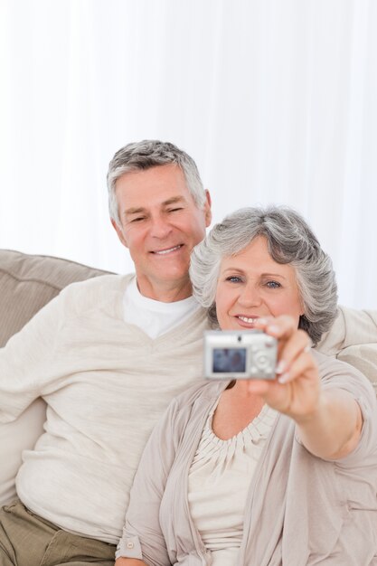 Pareja madura tomando una foto de sí mismos en casa