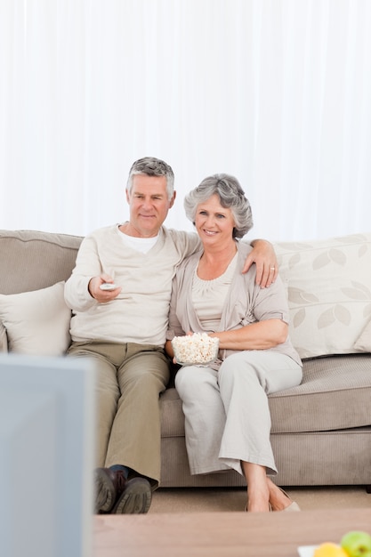 Pareja madura viendo la televisión en su sala de estar