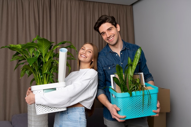 Foto pareja manejando cajas de pertenencias después de mudarse a una casa nueva