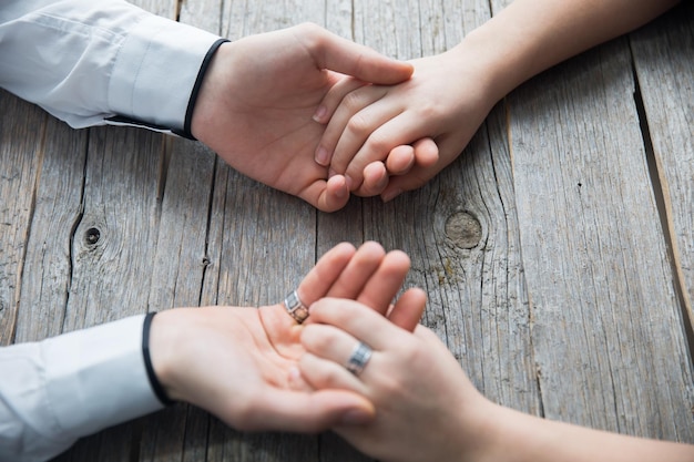 Pareja de la mano en la mesa de madera