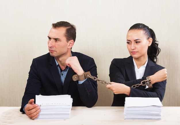 Pareja con manos encadenadas leyendo un concepto de contrato