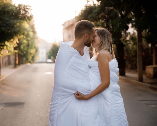 Foto una pareja en mantas paseando por la ciudad.