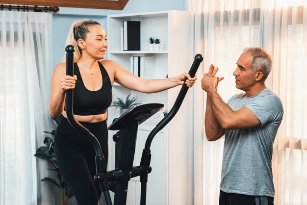 Pareja mayor activa corriendo en una máquina elíptica en casa juntos como estilo de vida saludable y cuidado del cuerpo después de la jubilación para el pensionista Clout