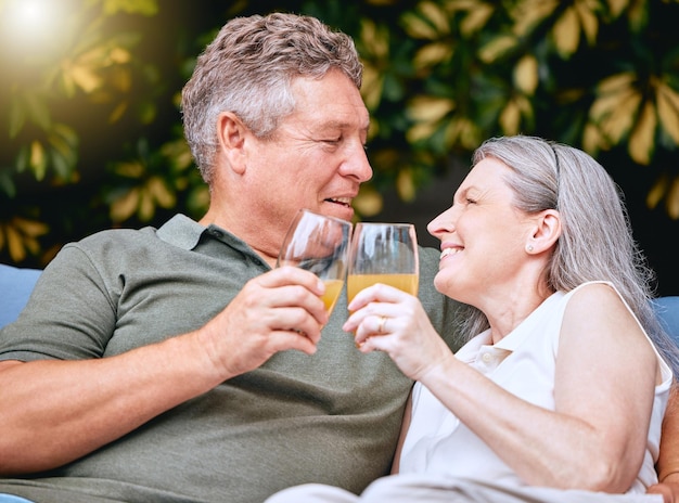 Pareja mayor y brindis de vacaciones con cóctel o jugo para relajar el romance o la vinculación en la naturaleza Anciano mujer y jubilación con sonrisa feliz y amor con vidrio en el jardín juntos