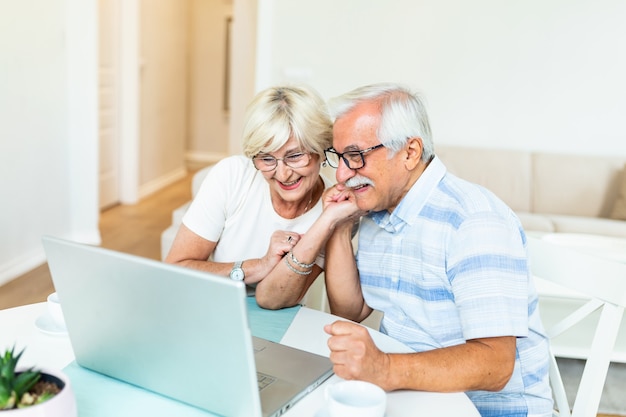La pareja mayor está hablando en línea a través de una conexión de video en la computadora portátil