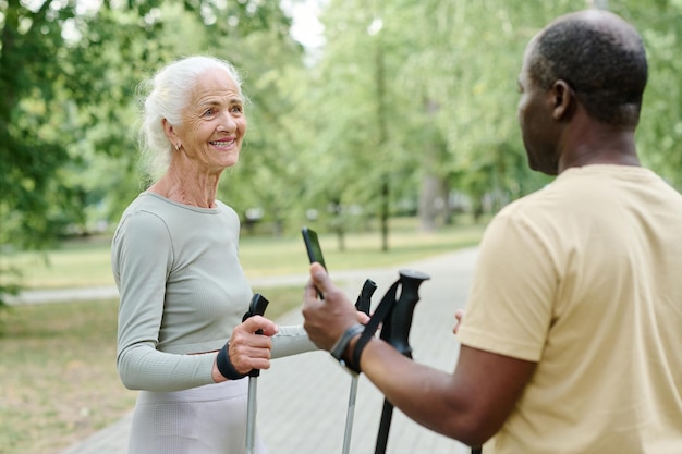 Una pareja mayor hablando entre sí mientras entrenan juntos al aire libre