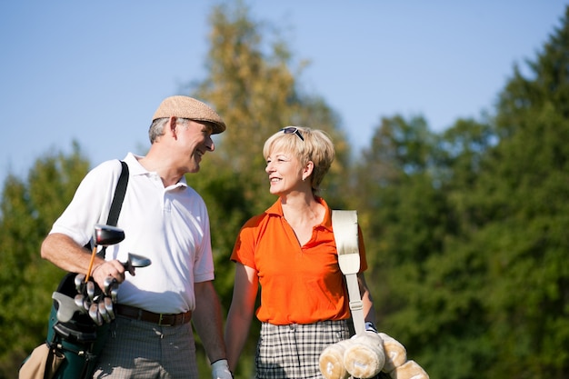 Pareja mayor, jugando golf