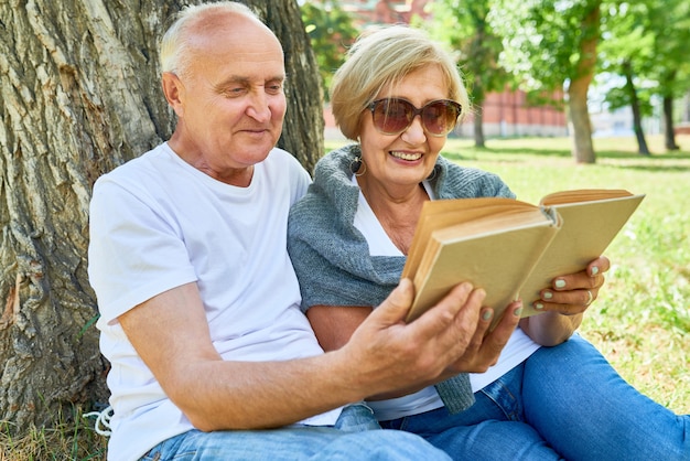 Pareja mayor, leer un libro, afuera