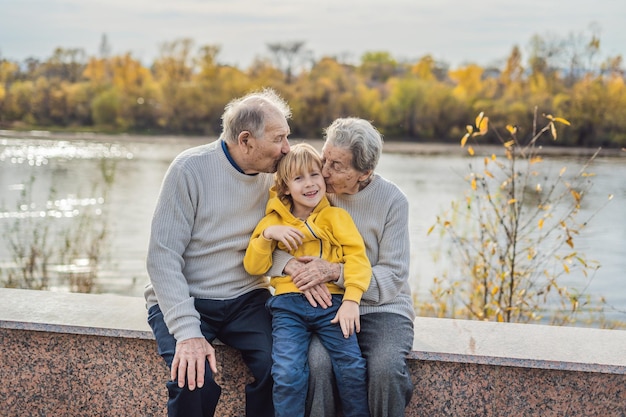 Pareja mayor con nieto en el parque de otoño. Bisabuela, bisabuelo y bisnieto