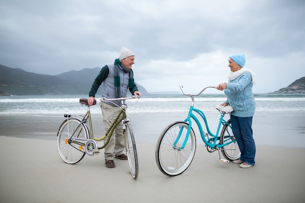 Pareja mayor, posición, con, bicicletas, en la playa