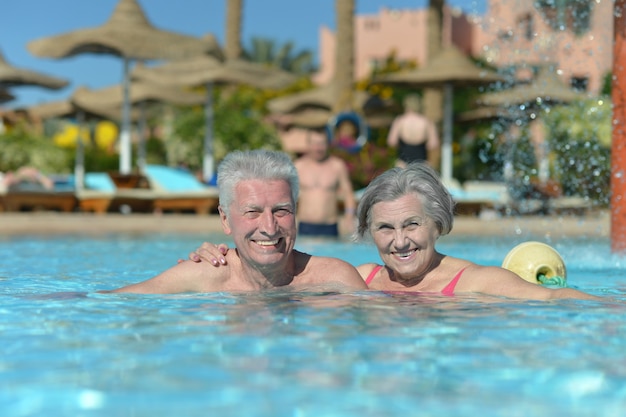 Pareja mayor, relajante, en, piscina, en, hotel resort