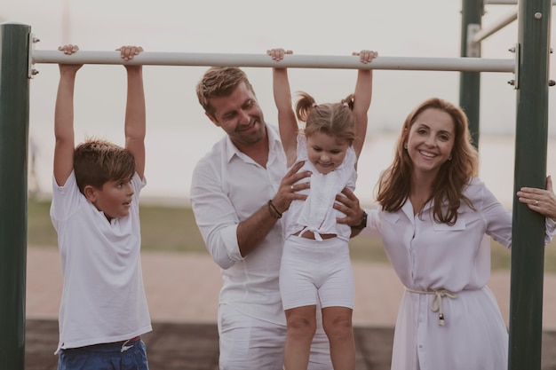 Una pareja mayor con ropa informal con sus hijos pasando tiempo en el parque unas vacaciones juntos en familia