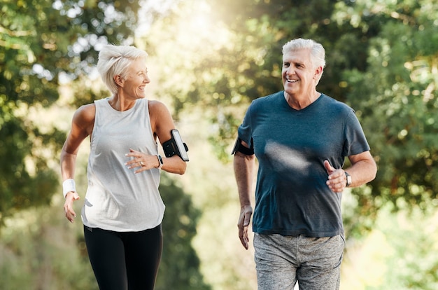 Pareja mayor de salud y correr en la naturaleza o en el parque para hacer ejercicio, fitness y bienestar Jubilación, hombre y mujer mayores, disfrutan de caminar al aire libre y hablar en el bosque para hacer ejercicio, entrenar y relajarse