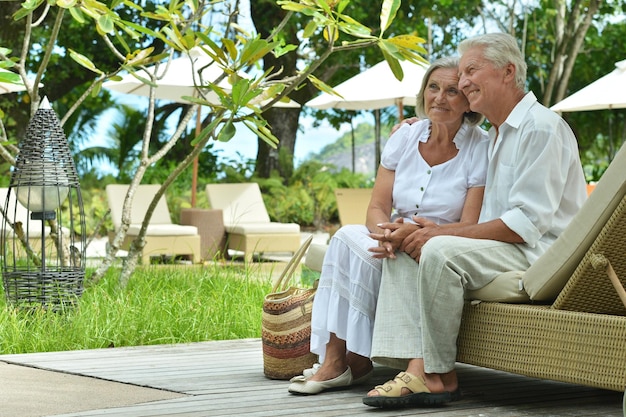 pareja mayor, sentado, en, chaise lounge