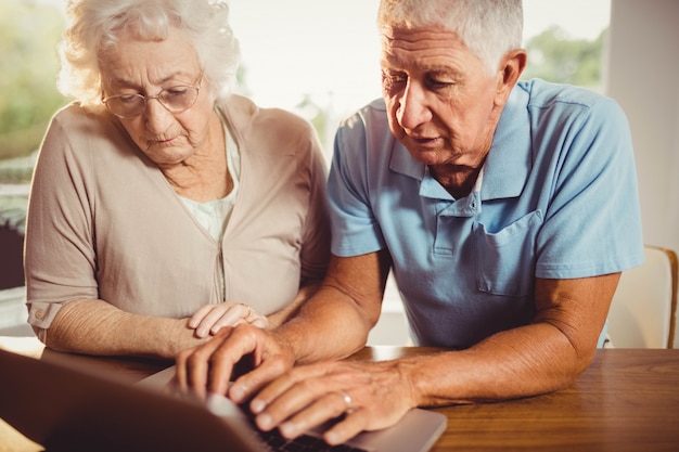 Pareja mayor, usar la computadora portátil, en casa