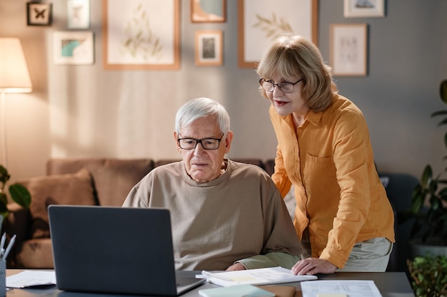 Pareja mayor, usar la computadora portátil, en casa