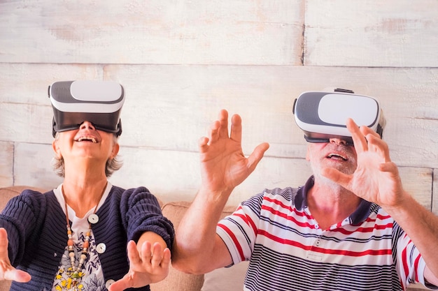 Una pareja de mayores con un simulador de realidad virtual en casa