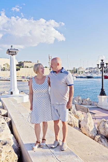 Pareja de mediana edad de baby boomers personas posando para la fotografía frente al mar azul