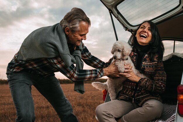 Pareja de mediana edad con su perro en un picnic