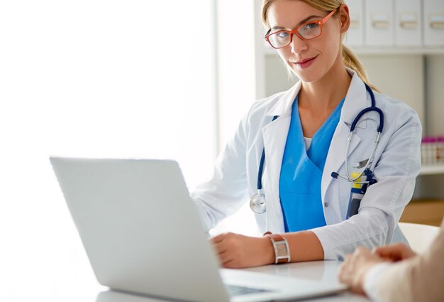 Foto la pareja de médicos y pacientes está discutiendo algo sentado en el escritorio