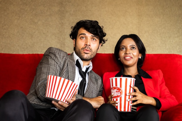 Pareja mira películas en el teatro con palomitas de maíz sonrisa y cara feliz